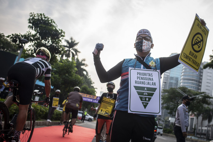 Anggota komunitas Bike to Work (B2W) Indonesia memegang poster saat melakukan aksi simpatik bertajuk Yang Bersepeda Yang Istimewa di Jalan Jenderal Sudirman, Senayan, Jakarta.
