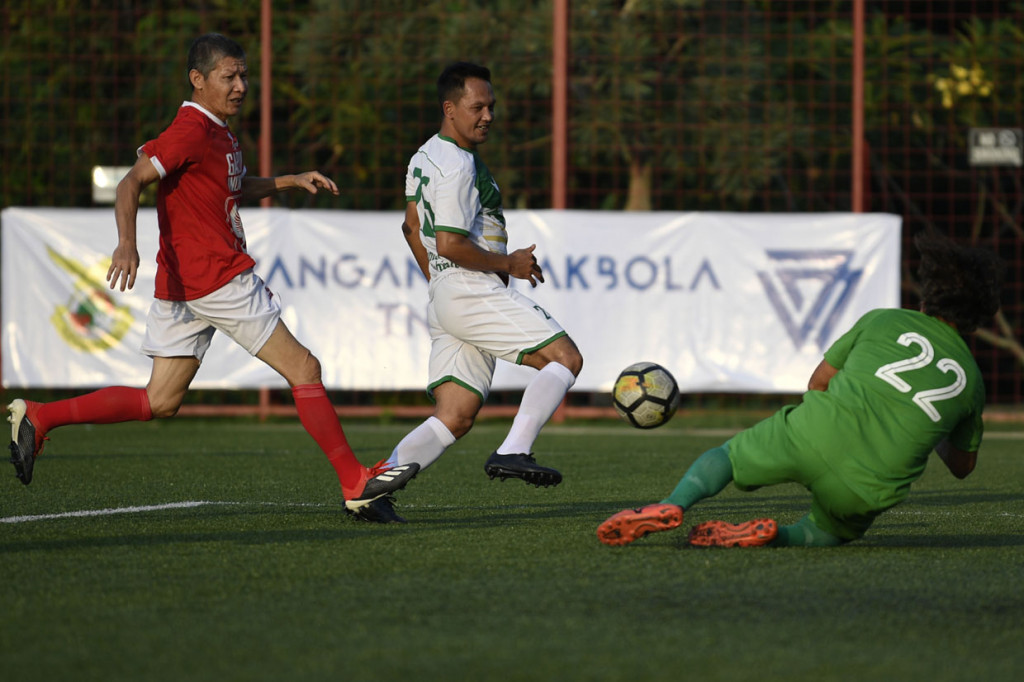 Pesepak bola Primavera-Baretti Indonesia Rachmat Afandi (tengah) berebut bola dengan pesepak bola Garuda Indonesia Marzuki Nyakmad (kiri) dalam pertandingan persahabatan di Jakarta.