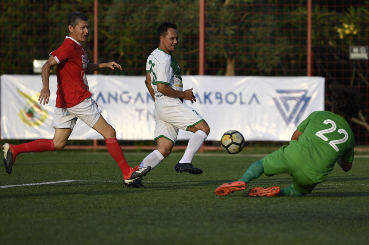 Pesepak bola Primavera-Baretti Indonesia Rachmat Afandi (tengah) berebut bola dengan pesepak bola Garuda Indonesia Marzuki Nyakmad (kiri) dalam pertandingan persahabatan di Jakarta.