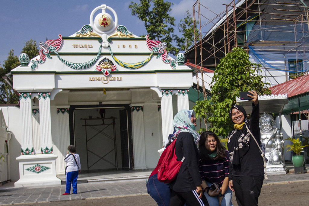 Wisatawan berfoto bersama saat mengunjungi kompleks Keraton Yogyakarta, DI Yogyakarta, Selasa, 14 Juli 2020.