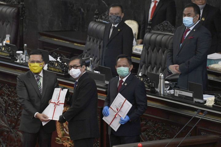 Ketua Komisi II DPR RI Ahmad Doli Kurnia Tanjung (kiri) menyerahkan dokumen UU Pilkada kepada Menteri Hukum dan HAM Yasonna Laoly (kedua kiri) dan Mendagri Tito Karnavian disaksikan pimpinan DPR Sufmi Dasco Ahmad dan Rachmat Gobel saat Rapat Paripurna ke-18 Masa Persidangan IV Tahun Sidang 2019-2020, di Kompleks Parlemen Senayan, Jakarta.