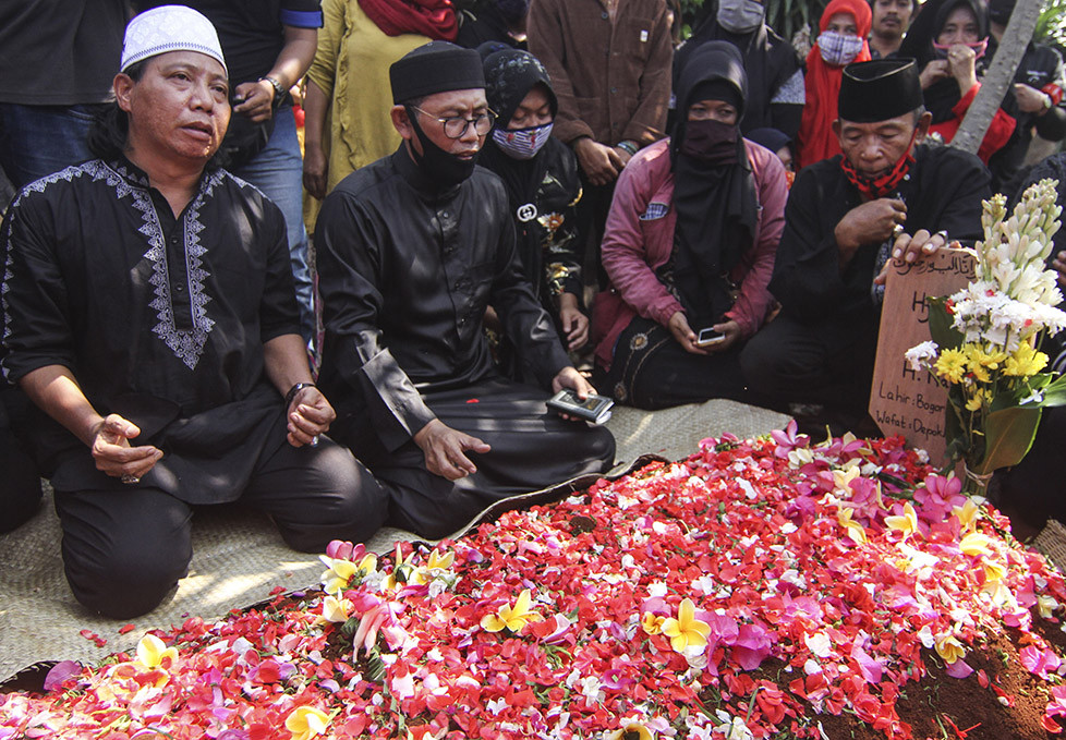 Adik almarhum Omaswati, Mastur (kiri) bersama keluarga membacakan doa saat pemakaman di Tempat Pemakaman Umum (TPU) Pedurenan, Cimanggis, Depok, Jawa Barat, Jumat, 17 Juli 2020. 