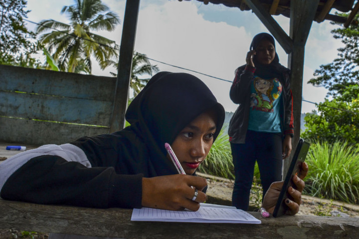 Siswa kelas IX Sekolah Menengah Pertama (SMP) Plus Pasawahan mengerjakan tugas sekolah di pos kamling Desa Pasawahan, Kabupaten Ciamis, Jawa Barat, Kamis, 16 Juli 2020.