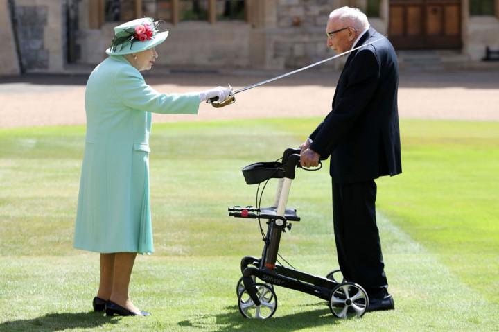 Ratu Inggris Elizabeth II menggunakan pedang milik ayahnya, George VI saat menganugerahkan Honor of Knighthood kepada veteran Kapten Tom Moore yang berusia 100 tahun di Kastil Windsor di Windsor, sebelah barat London, Jumat, 17 Juli 2020 waktu setepat. 