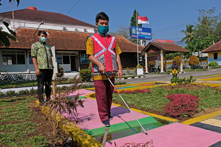 Penyandang disabilitas sensorik netra Sumarno (kanan) mencoba rompi 'Penganthi' (penuntun dengan teknologi) dan tongkat putih di kompleks Panti Pelayanan Sosial Disabilitas Sensorik Netra (PPSDSN) 'Penganthi' Temanggung, Jawa Tengah, Rabu, 22 Juli 2020. 