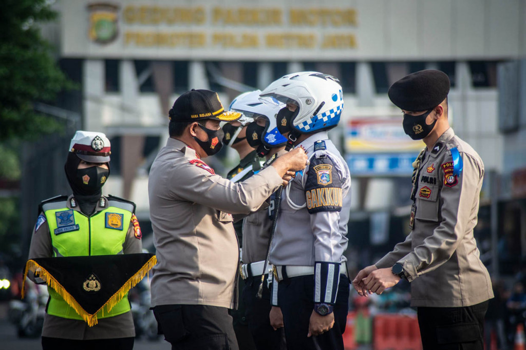 Kapolda Metro Jaya Irjen Nana Sudjana menyematkan pita tanda operasi kepada perwakilan petugas dalam Apel gelar Pasukan Operasi Patuh Jaya Tahun 2020 di Polda Metro Jaya, Jakarta, Kamis, 23 Juli 2020. Operasi Patuh Jaya 2020 digelar selama 14 hari dimulai pada 23 Juli hingga 5 Agustus 2020.