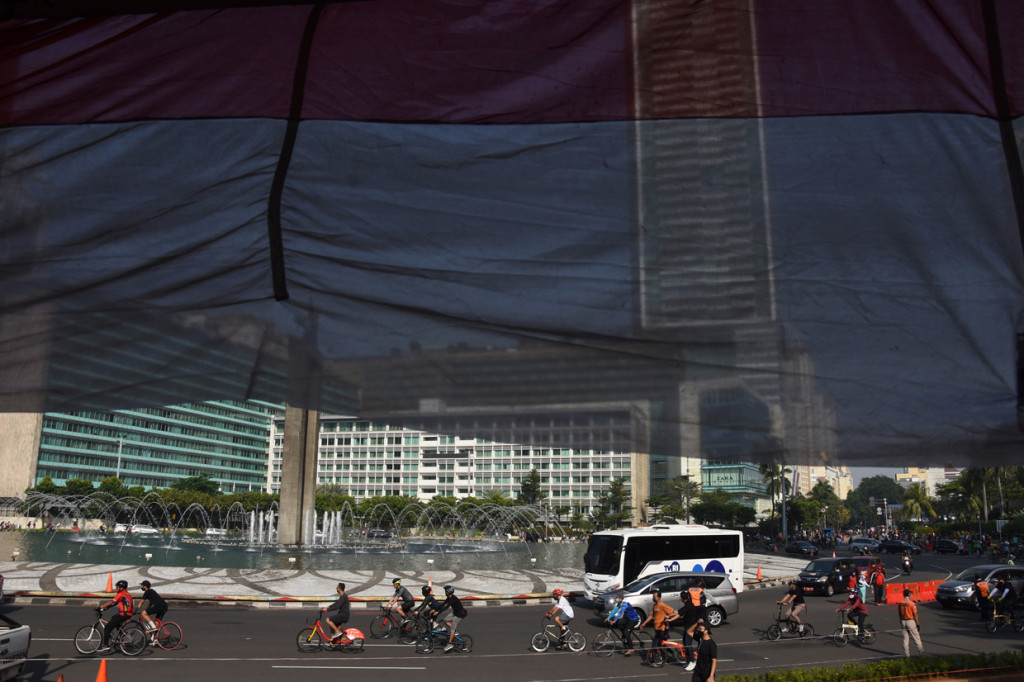 Warga berolahraga menggunakan sepeda di kawasan Bundaran HI, Jakarta.