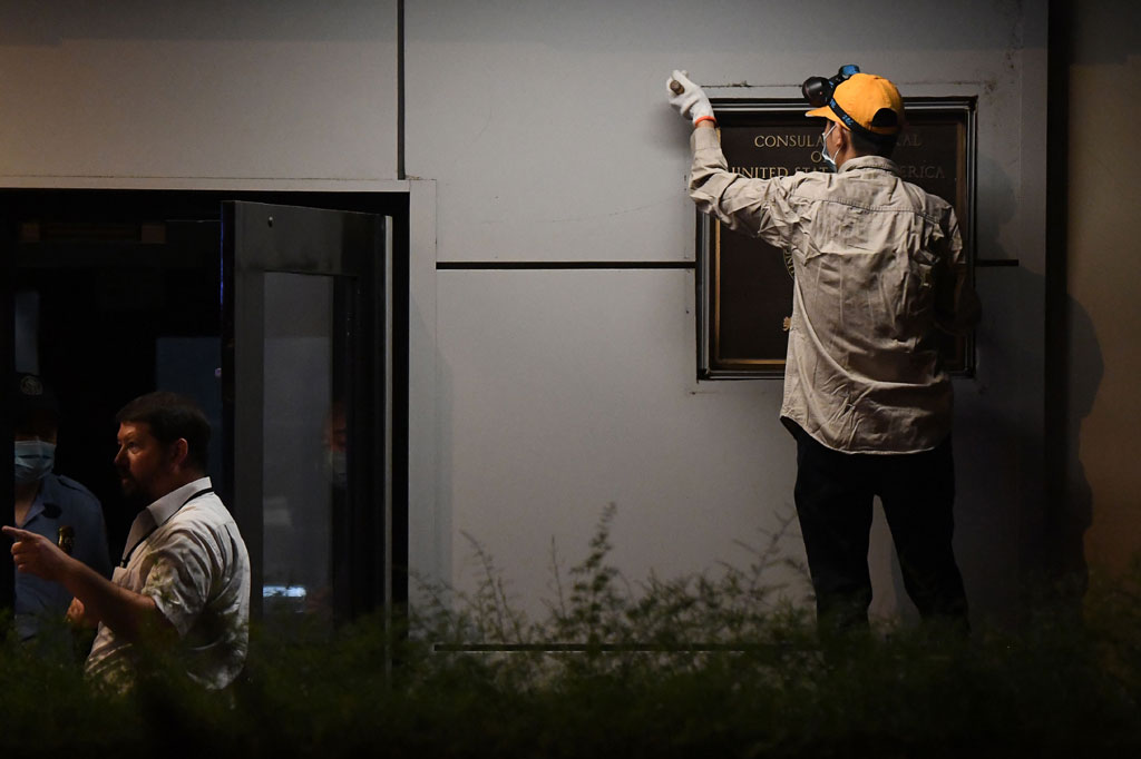 Pekerja mencopot plakat yang tertempel di dinding Konsulat AS di Kota Chengdu, Tiongkok, Minggu, 26 Juli 2020.