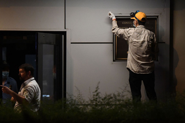 Pekerja mencopot plakat yang tertempel di dinding Konsulat AS di Kota Chengdu, Tiongkok, Minggu, 26 Juli 2020.
