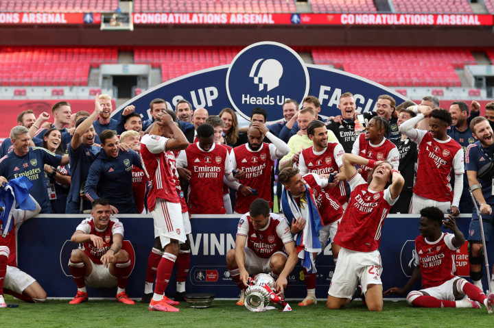 Ketika Aubameyang hendak mengangkat piala tersebut, tiba-tiba alas bawah piala yang dipegangnya tergelincir dan membuat trofi Piala FA di atasnya terjatuh ke tanah. AFP Photo/Cathrtine Ivill