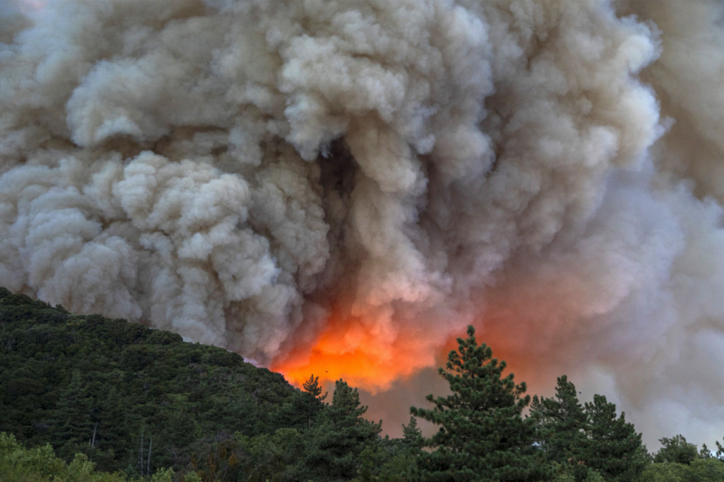 Kobaran hebat Apple Fire menimbulkan kepulan asap tebal yang dapat terlihat dari kejauhan. Tebalnya asap membuat otoritas setempat mendeklarasikan status waspada kualitas udara pada Sabtu malam. AFP Photo/David Mcnew