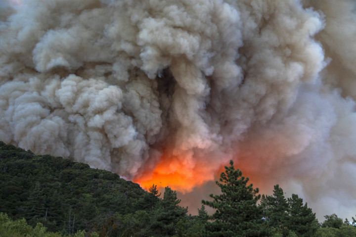 Kobaran hebat Apple Fire menimbulkan kepulan asap tebal yang dapat terlihat dari kejauhan. Tebalnya asap membuat otoritas setempat mendeklarasikan status waspada kualitas udara pada Sabtu malam. AFP Photo/David Mcnew
