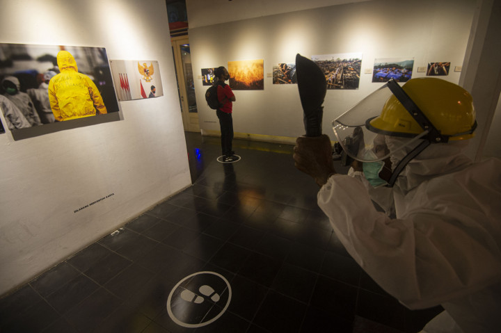 Pengunjung mengamati karya pameran fotografi 'Kilas Balik 2019 + COVID-19' di Galeri Foto Jurnalistik Antara (GFJA), Pasar Baru, Jakarta.