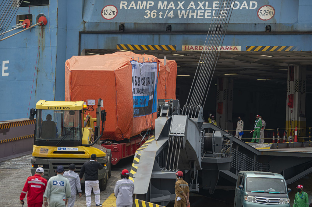 Sejumlah petugas dibantu alat berat bersiap memasukkan garbarata (jembatan penghubung ruang tunggu penumpang ke pintu pesawat terbang) buatan PT Bukaka Teknik Utama Tbk di dermaga IPC Car Terminal, Pelabuhan Tanjung Priok, Jakarta, Selasa, 4 Agustus 2020.