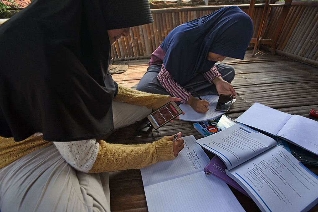 Warga setempat yang terhimpun dalam Komunitas Digital Serang (KDS) bekerja sama dengan pengurus lingkungan menyediakan akses internet gratis guna membantu para pelajar dari keluarga kurang mampu mengikuti pembelajaran secara daring. ANTARA FOTO/Asep Fathulrahman