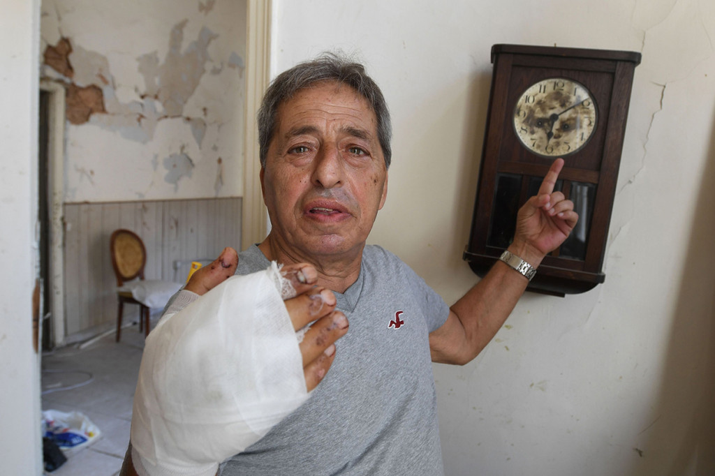 Seorang pria Lebanon dengan tangan terluka menunjuk ke jam dindingnya yang berhenti berdetak pada pukul 06.07, momen saat ledakan dahsyat terjadi di Pelabuhan Beirut yang menghancurkan sebagian besar Ibu Kota Lebanon, Selasa, 4 Agustus 2020 lalu.