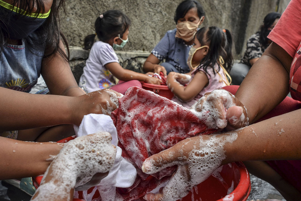 Sejumlah warga mengikuti tradisi Mencuci Bendera Merah Putih di Gang Warga, Lingkungan Janggala, Kabupaten Ciamis, Jawa Barat, Jumat, 14 Agustus 2020.