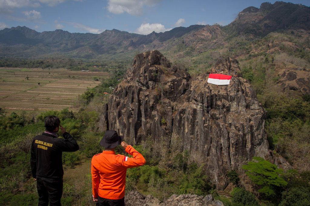 Puluhan pemuda yang tergabung dalam sejumlah organisasi mengibarkan Bendera Merah Putih raksasa di puncak bukit Gunung Sepikul, Sukoharjo, Jawa Tengah, Sabtu, 15 Agustus 2020.