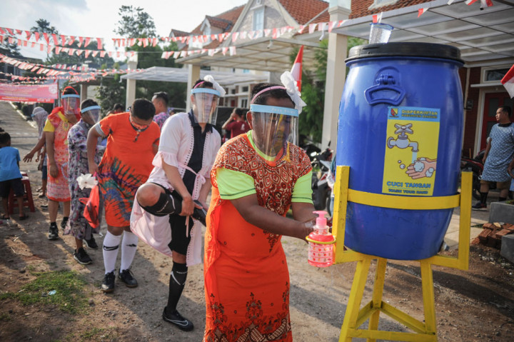 Peserta lomba antre untuk mencuci tangannya sebelum melaksanakan perlombaan sepak bola pria dengan kostum wanita di Cinunuk, Kabupaten Bandung, Jawa Barat, Sabtu, 15 Agustus 2020.