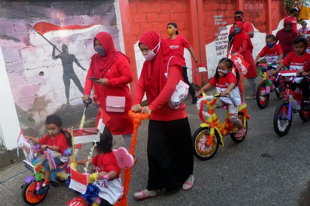 Peserta mengenakan masker dan pelindung wajah saat mengikuti pawai kemerdekaan menuju Jalan Keadilan di Rangkapan Jaya Baru, Depok, Jawa Barat. ANTARA Foto/Wahyu Putro A