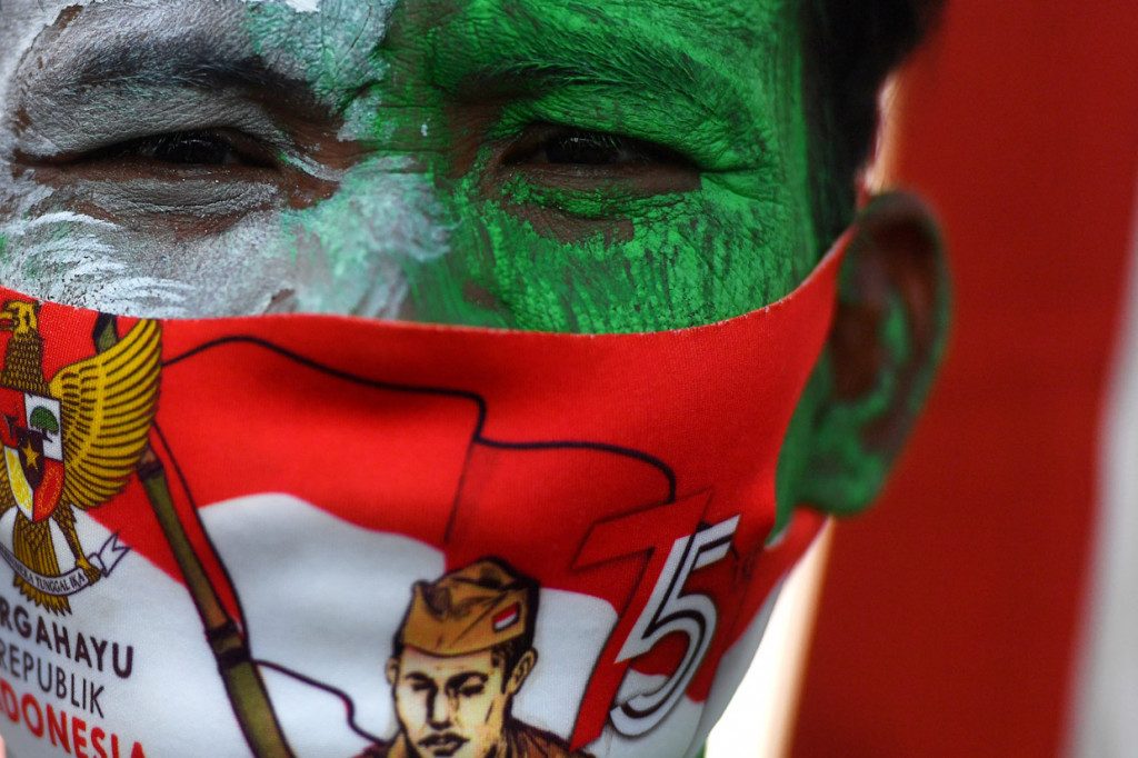 Seorang anggota Komunitas Sepeda Tua Indonesia Surabaya mengikuti upacara Kemerdekaan Indonesia di depan Hotel Majapahit, Surabaya, Jawa Timur.
