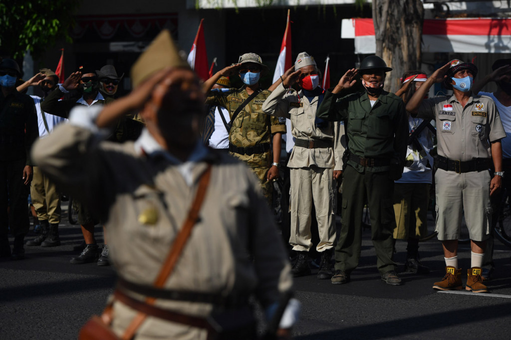 Seorang anggota Komunitas Sepeda Tua Indonesia Surabaya mengikuti upacara Kemerdekaan Indonesia di depan Hotel Majapahit, Surabaya, Jawa Timur.

