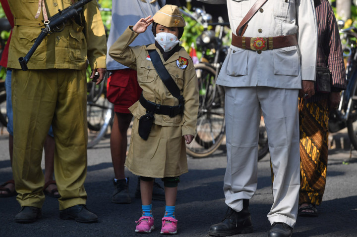Seorang anak anggota Komunitas Sepeda Tua Indonesia Surabaya berpakaian pasukan perjuangan memberi hormat kepada bendera Merah Putih ketika mengikuti upacara Kemerdekaan Indonesia di depan Hotel Majapahit, Surabaya, Jawa Timur.