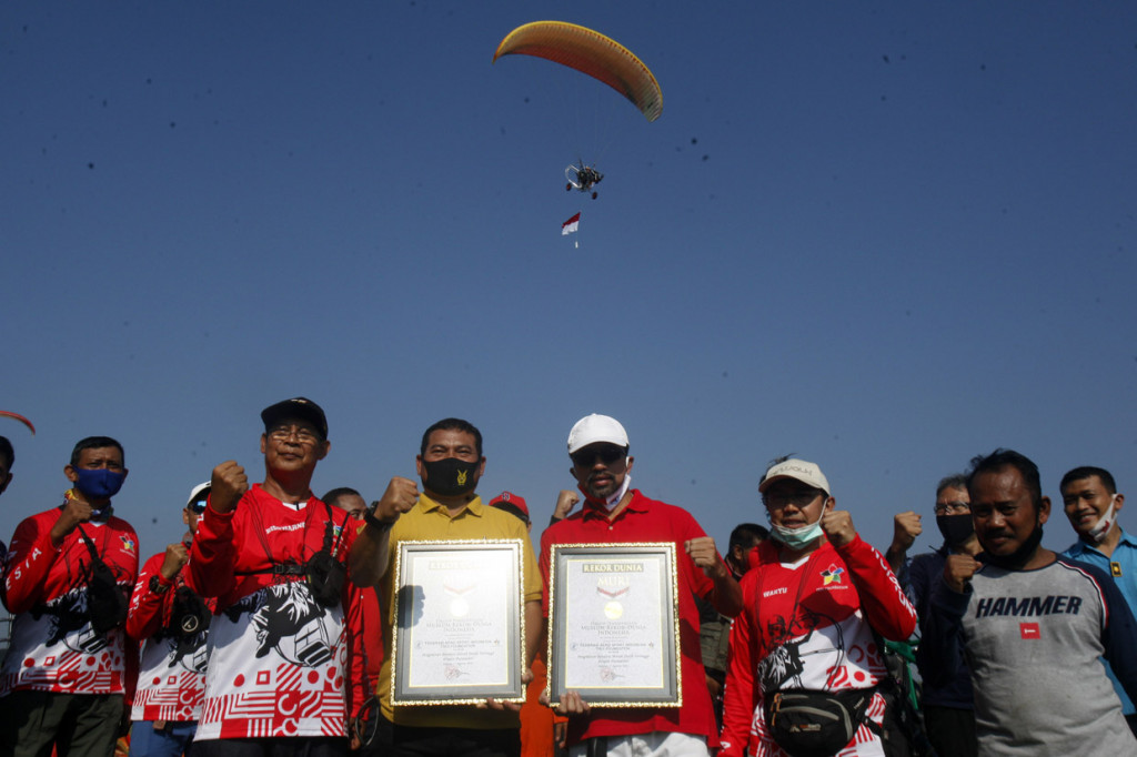 Sekjen Federasi Aero Sport Indonesia (FASI) Marsma TNI Basuki Rochmat (ketiga kiri) dan Asisten Deputi Pengelolaan Olahraga Rekreasi Kemenpora Maifrizon (ketiga kanan) menunjukan piagam rekor Museum Rekor Indonesia (MURI) setelah pemecahanan rekor pengibaran bendera Merah Putih tertinggi di Lanud Atang Sendjaja (ATS), Kabupaten Bogor, Jawa Barat.