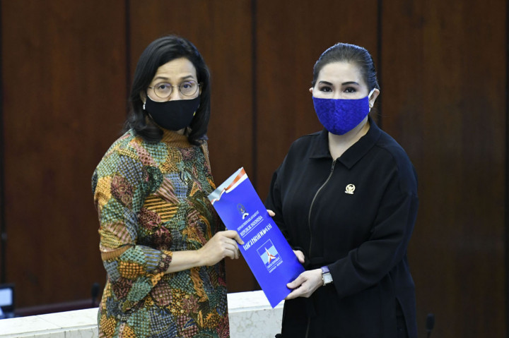 Menteri Keuangan Sri Mulyani (kiri) menerima laporan pandangan dari fraksi Demokrat yang diwakili oleh Vera Febyanthy (kanan) disela Rapat Paripurna ke-2 Masa Persidangan 2020-2021 di Kompleks Parlemen, Senayan, Jakarta.