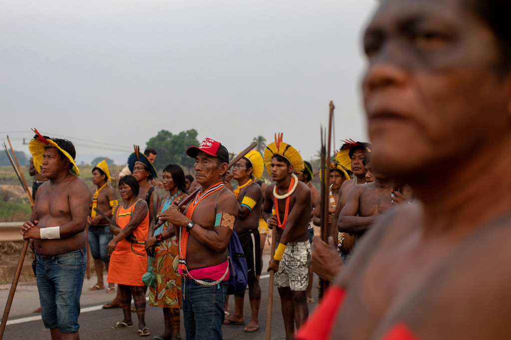 Mengacungkan busur dan mengenakan hiasan kepala bulu tradisional dan cat tubuh, puluhan pengunjuk rasa dari kelompok etnis Kayapo Mekranoti tersebut telah memblokade jalan raya BR-163 yang melalui hutan hujan Amazon sejak Senin, 17 Agustus 2020 pagi.