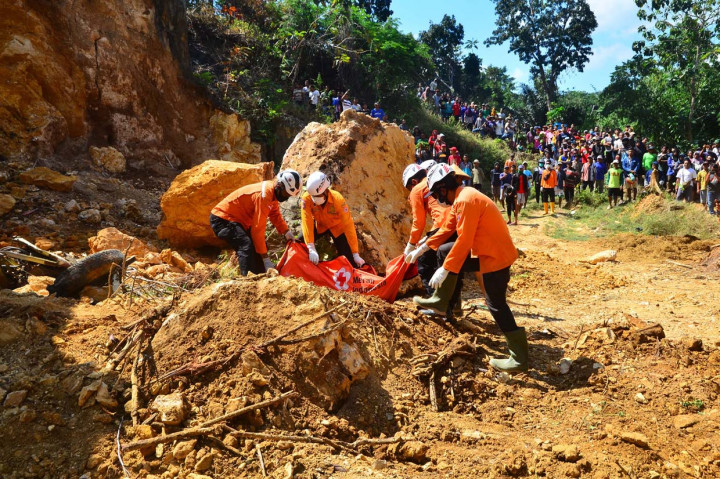 Petugas Basarnas membungkus jenazah korban bencana tebing longsor di lokasi galian C penambangan batu di desa Katekan, Brati, Grobogan, Jawa Tengah.
