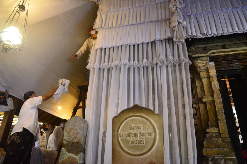 Sejumlah warga melepas Luwur atau kain mori penutup makam Sunan Kudus untuk diganti dengan yang baru saat prosesi buka luwur di Desa Kauman, Kudus, Jawa Tengah, Kamis, 20 Agustus 2020.