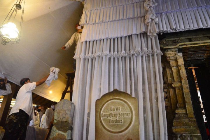 Sejumlah warga melepas Luwur atau kain mori penutup makam Sunan Kudus untuk diganti dengan yang baru saat prosesi buka luwur di Desa Kauman, Kudus, Jawa Tengah, Kamis, 20 Agustus 2020.