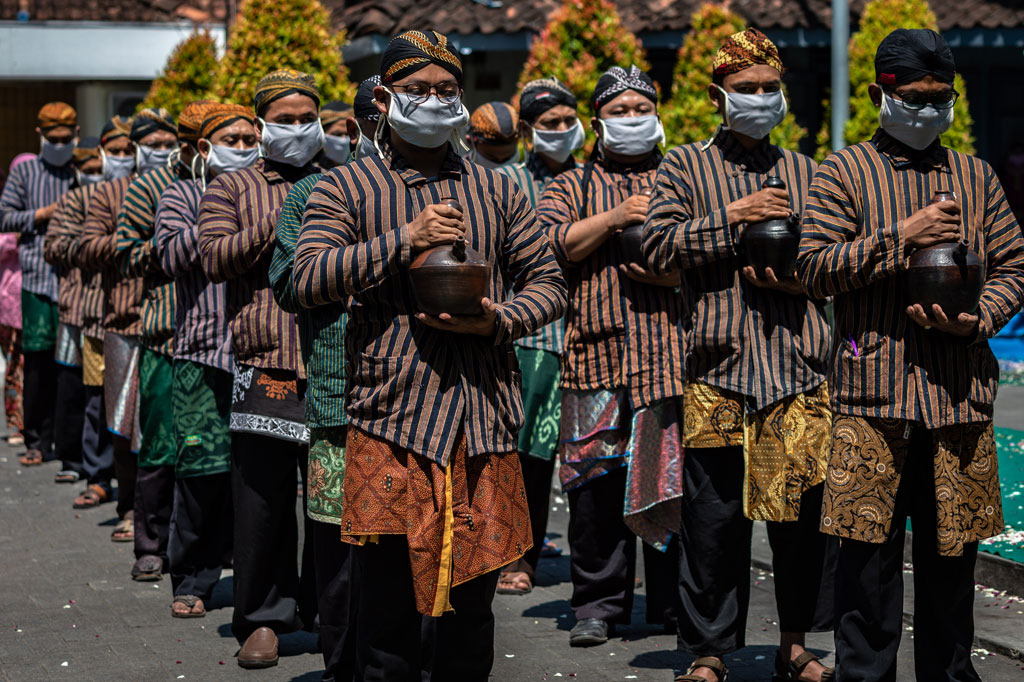 Pasukan Patangpuluh Kendi Kasepuhan Girikusumo dengan mengenakan masker mengirab kendi berisi air dari sumur berkah Girikusumo sebagai simbol berkah alam dalam prosesi Tradisi Kirab Sura Girikusumo.