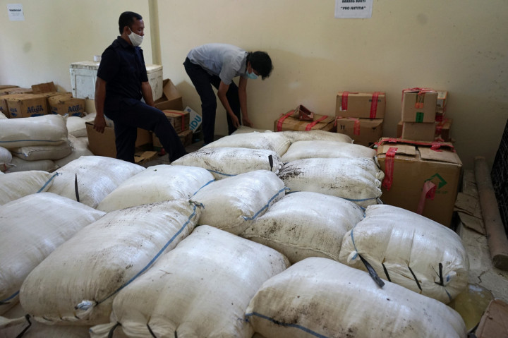Dua orang petugas mengamankan minuman keras tanpa merk jenis cap tikus di kantor Balai Pengawas Obat dan Makanan (BPOM) di Kabupaten Bone Bolango, Gorontalo.