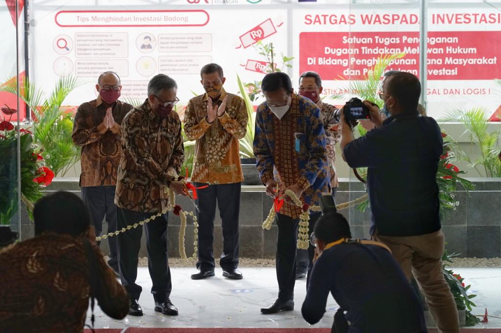 Ketua Dewan Komisioner Otoritas Jasa Keuangan (OJK) Wimboh Santoso (kedua kiri) bersama Gubernur Daerah Istimewa Yogyakarta (DIY) Sri Sultan HB X (kedua kanan) memotong tali bunga saat peresmian gedung baru OJK DIY di Jalan Jenderal Sudirman No.32, Yogyakarta.
