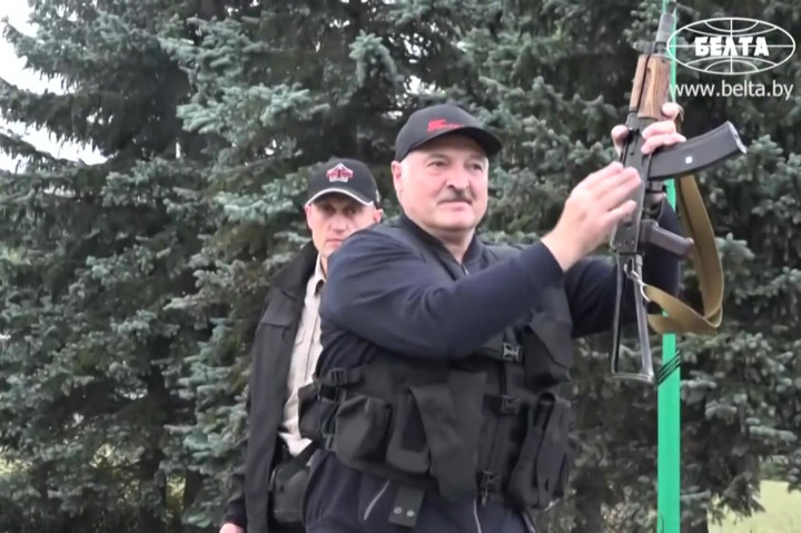 Lukashenko turun memegang senapan otomatis jenis Kalashnikov.