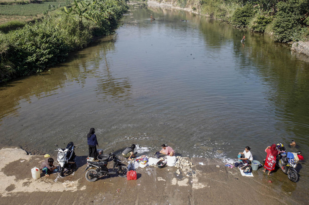 Musim kemarau membuat sebagian warga di kawasan tersebut terpaksa mencuci dan mandi di sungai karena sumur di rumah mereka kering.