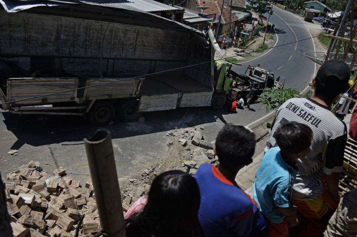 Warga melihat proses evakuasi truk pengangkut susu kemasan yang terguling di Nagreg, Kabupaten Bandung, Jawa Barat.
