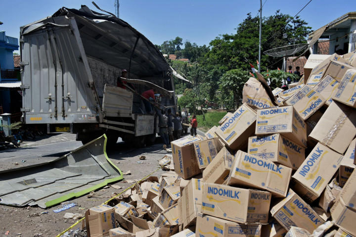 Petugas derek mengevakuasi truk pengangkut susu kemasan yang terguling di Nagreg, Kabupaten Bandung, Jawa Barat.
