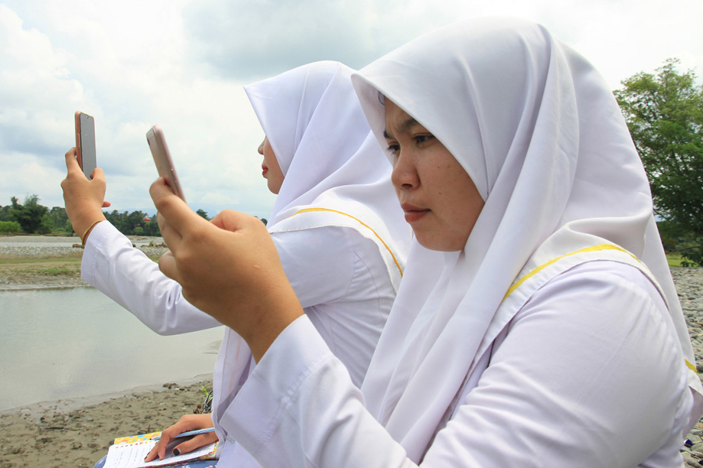 Untuk mendapatkan sinyal mereka terpaksa mencari jaringan di tempat terbuka seperti di pinggir sungai dan di atas pegunungan.