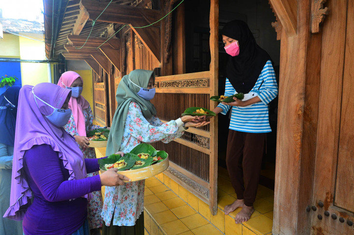 Warga menerima bubur saat tradisi membagi bubur asyura di kompleks Masjid Menara Kudus di Desa Kauman, Kudus, Jawa Tengah, Jumat, 28 Agustus 2020. 