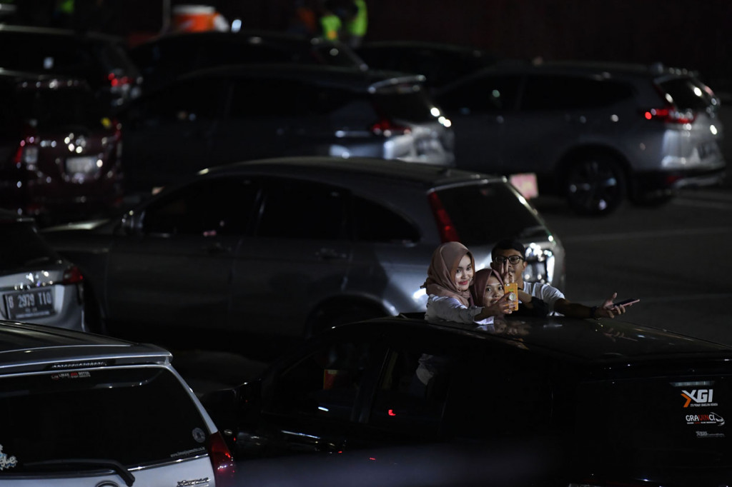 Penonton berswafoto saat menyaksikan penampilan Kahitna dalam konser New Live Experience 2020 di Parkir Barat JIExpo Kemayoran, Jakarta.
