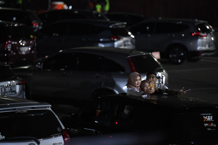 Penonton berswafoto saat menyaksikan penampilan Kahitna dalam konser New Live Experience 2020 di Parkir Barat JIExpo Kemayoran, Jakarta.
