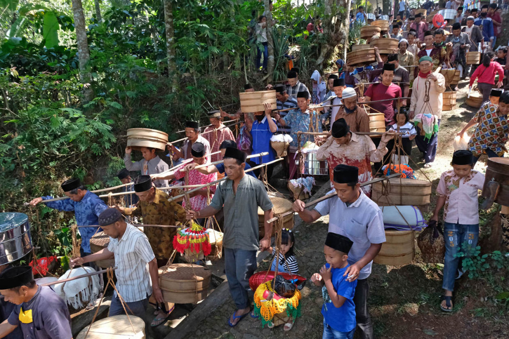 Sejumlah warga membawa Tenong berisi berbagai jenis makanan dan nasi Tumpeng saat tradisi Nyadran Kyai Kramat di kawasan hutan Pinus Desa Tlogopucang, Kandangan, Temanggung, Jawa Tengah.