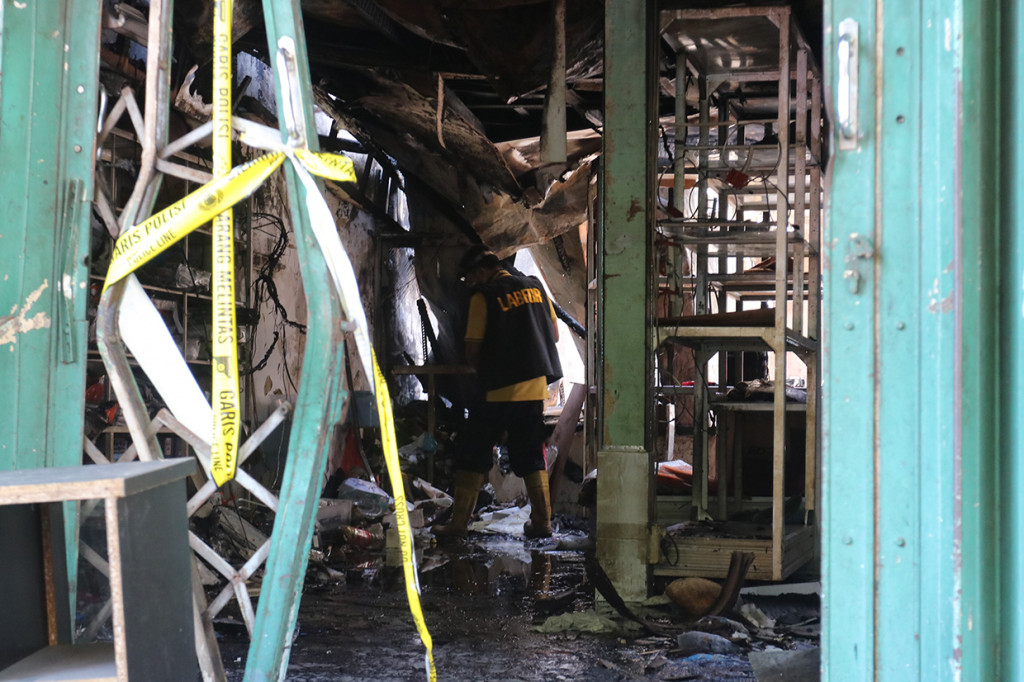 Personel Tim Laboratorium Forensik (Labfor) Polda Jawa Timur melakukan olah TKP di toko elektronik yang terbakar di Jalan Kranggan, Surabaya, Jawa Timur.