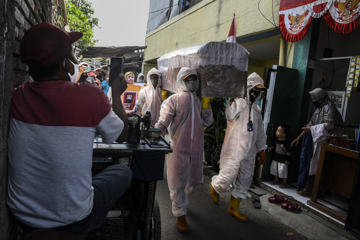 Petugas Kecamatan Cilandak membawa peti jenazah saat melakukan kampanye bahaya Covid-19 di Jakarta. 
