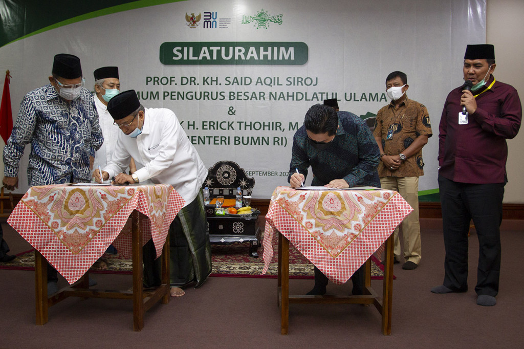 Menteri Badan Usaha Milik Negara (BUMN) Erick Thohir (kedua kanan) bersama Ketua Umum Pengurus Besar Nahdlatul Ulama (PBNU) Said Aqil Siradj (kedua kiri) melakukan penandatanganan nota kesepahaman (MoU) di Pondok Pesantren Luhur Al-Tsaqafah, Jakarta, Jumat, 4 September 2020. 