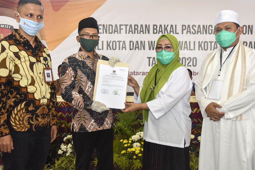 Ketua KPU Kota Mataram M Husni Abidin (kedua kiri) memberikan berita acara kelengkapan berkas pendaftaran kepada pasangan bakal calon Wali Kota dan Wakil Wali Kota Mataram Selly Andayani (kedua kanan) dan TG Abdul Manan (kanan) usai mendaftar di Kantor KPU Kota Mataram di Mataram, NTB, Sabtu, 5 September 2020. 