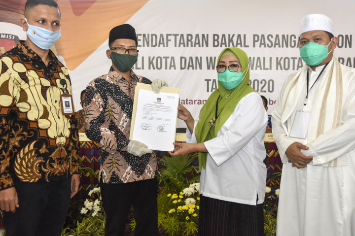 Ketua KPU Kota Mataram M Husni Abidin (kedua kiri) memberikan berita acara kelengkapan berkas pendaftaran kepada pasangan bakal calon Wali Kota dan Wakil Wali Kota Mataram Selly Andayani (kedua kanan) dan TG Abdul Manan (kanan) usai mendaftar di Kantor KPU Kota Mataram di Mataram, NTB, Sabtu, 5 September 2020. 